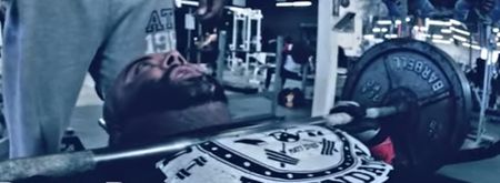 American bench press monster does interview while repping 405lbs barbell (Video)