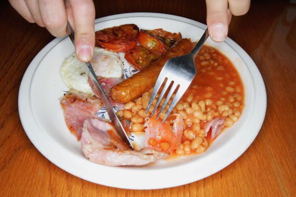 LONDON - APRIL 20: In this photo illustration an all English fry up breakfast is eaten, April 20, 2006 in London, England. The traditional English style breakfast 'Fry-Up' is under threat of being replaced by more continental style coffee shops. (Photo Illustration by Daniel Berehulak/Getty Images)