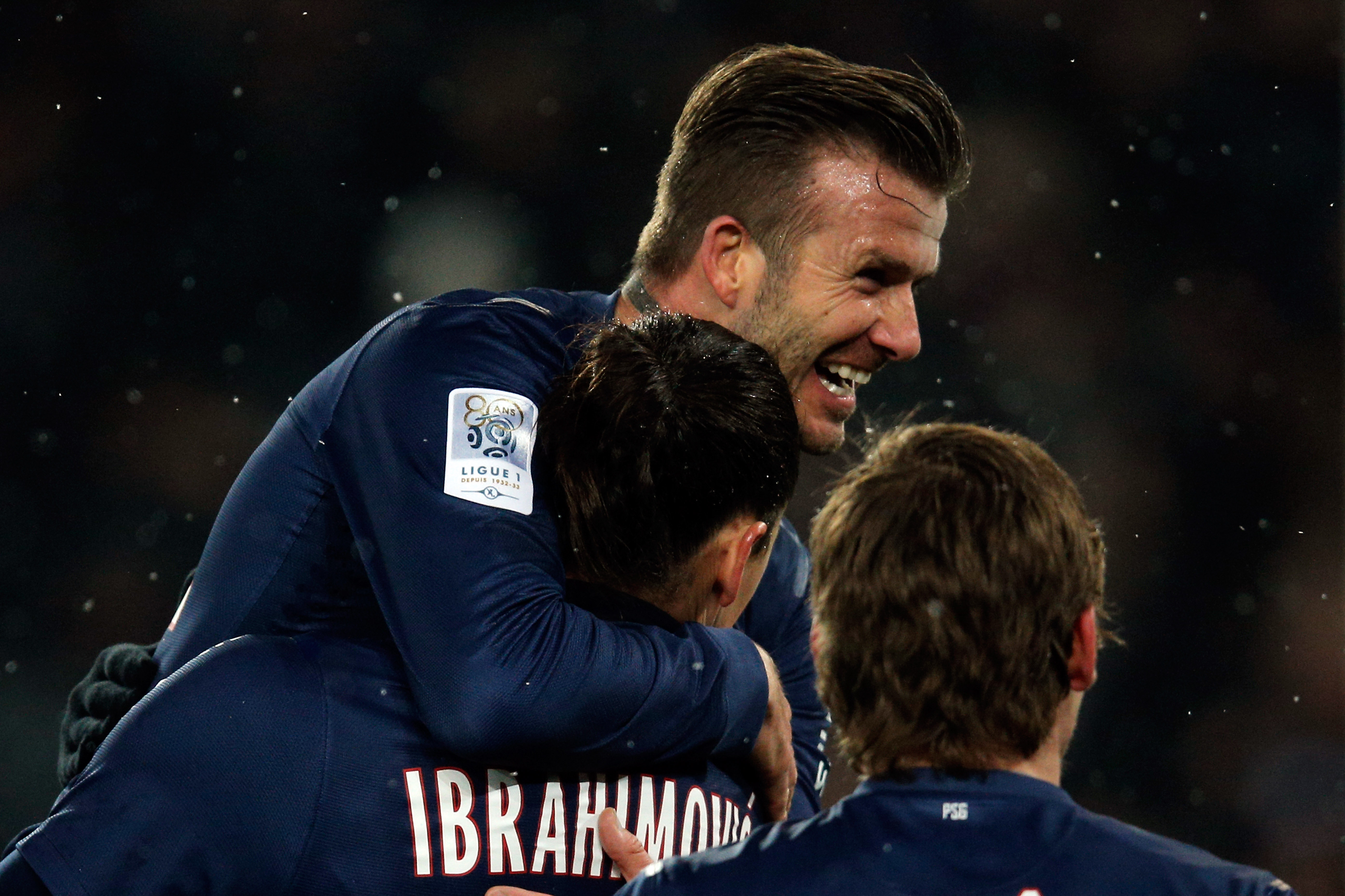 PARIS, FRANCE - FEBRUARY 24: David Beckham of PSG jumps on the goal scorer and team mate Zlatan Ibrahimovic during the Ligue 1 match between Paris Saint-Germain FC and Olympique de Marseille at Parc des Princes on February 24, 2013 in Paris, France. (Photo by Dean Mouhtaropoulos/Getty Images)