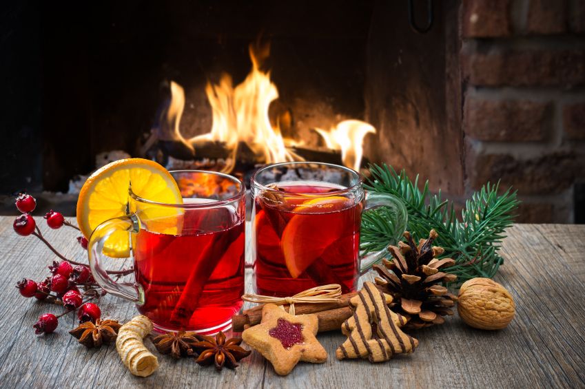 Delicious mulled wine with christmas decoration at romantic fireplace