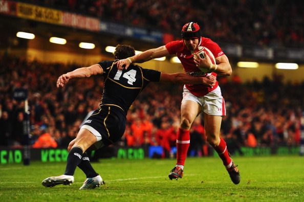 CARDIFF, WALES - FEBRUARY 12: Leigh Halfpenny (R) of Wales shakes off the tackle of Lee Jones (L) of Scotland to score a try during the RBS Six Nations match between Wales and Scotland at the Millenium Stadium on February 12, 2012 in Cardiff, Wales. (Photo by Mike Hewitt/Getty Images)