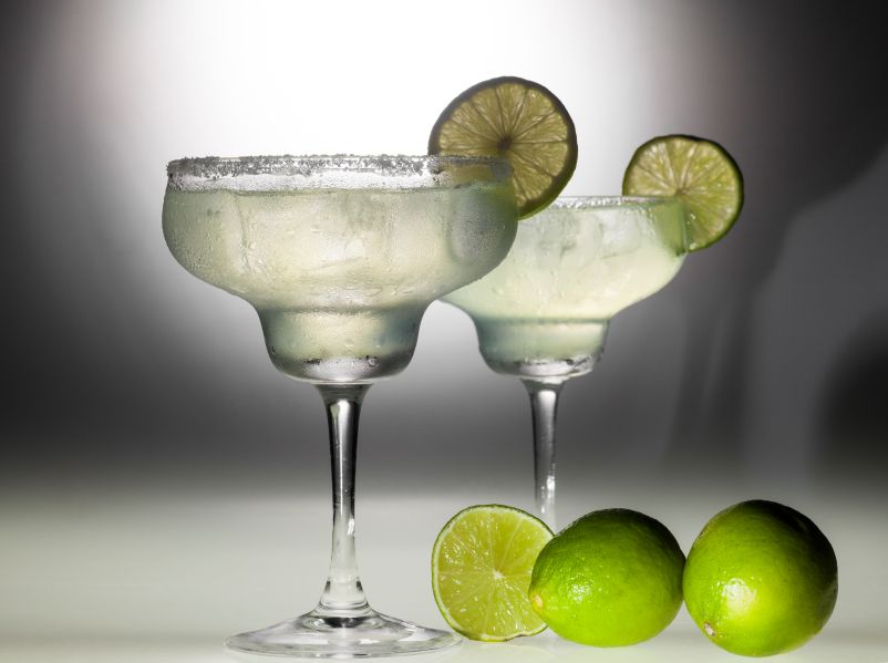 Two glasses of margarita coctail on black and white background with deep shadows.