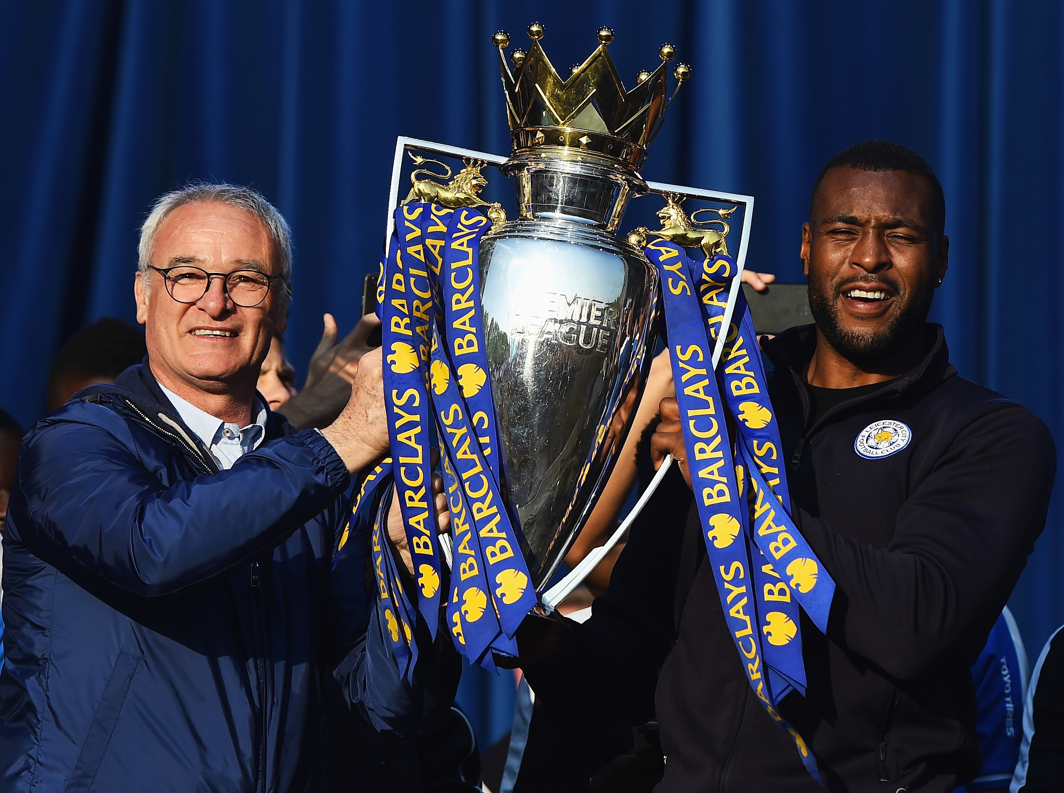 LEICESTER, ENGLAND - MAY 16: (L-R) Claudio Ranieri Manager of Leicester City and captain Wes Morgan of Leicester City show the trophy to the fans during the Leicester City Barclays Premier League winners bus parade on May 16, 2016 in Leicester, England. (Photo by Laurence Griffiths/Getty Images)