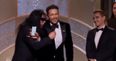 Tommy Wiseau tries to grab the microphone after James Franco’s win
