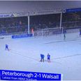 Peterborough player sweeps through snow to make pitch lines visible so match can finish