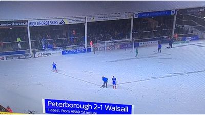 Peterborough player sweeps through snow to make pitch lines visible so match can finish