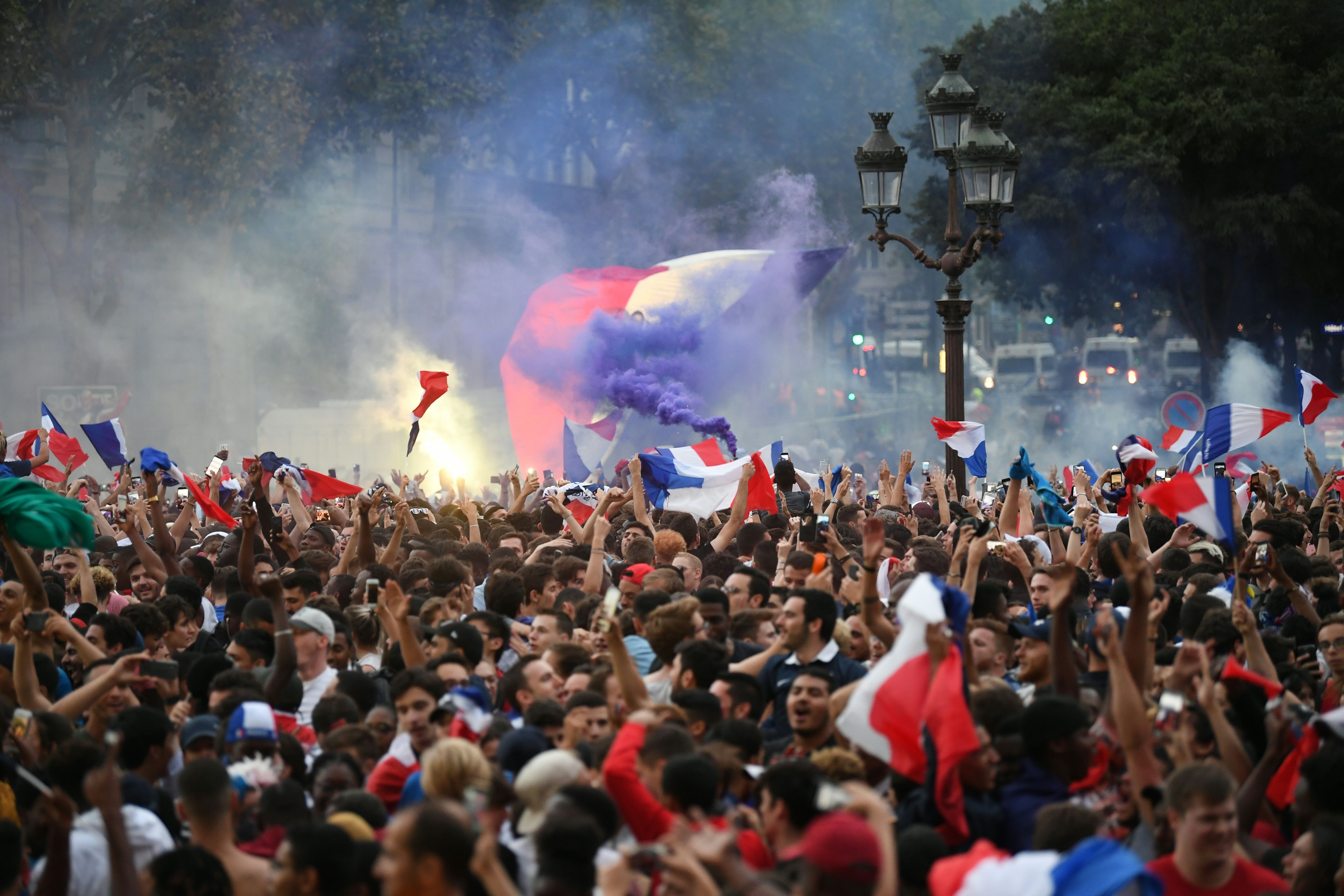 TOPSHOT - People celebrate France's victory at a fan zone in central Paris on July 10, 2018 at the final whistle of the Russia 2018 World Cup semi-final football match between France and Belgium. (Photo by Eric FEFERBERG / AFP) (Photo credit should read ERIC FEFERBERG/AFP/Getty Images)