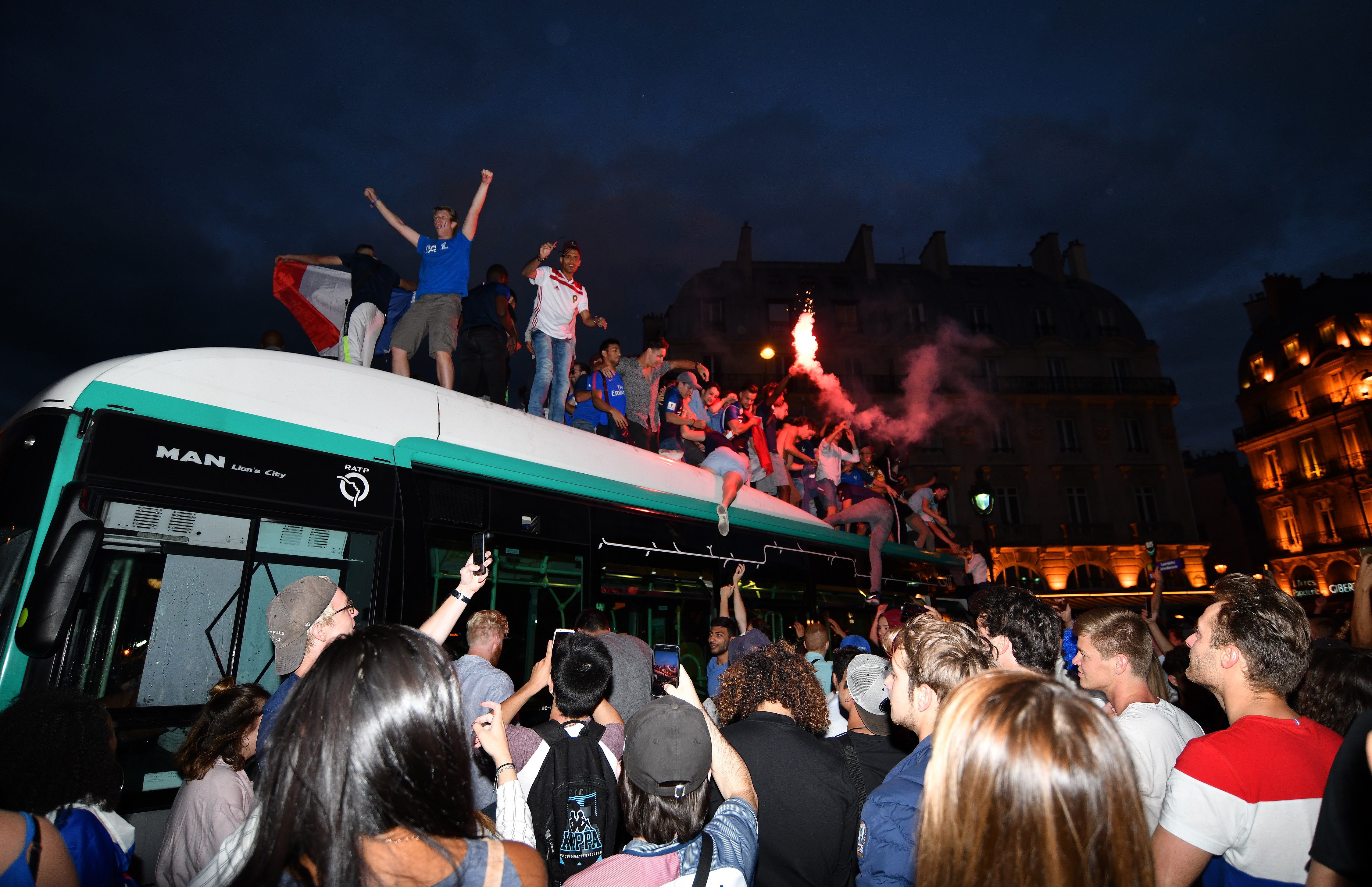 PARIS, FRANCE - JULY 10: Supporters of France football national team celebrate their team's victory against Belgium of the semifinal match in the FIFA 2018 World Cup, on top of a public bus at Place Saint-Michel in Paris, France on July 10, 2018. (Photo by Mustafa Yalcin/Anadolu Agency/Getty Images)