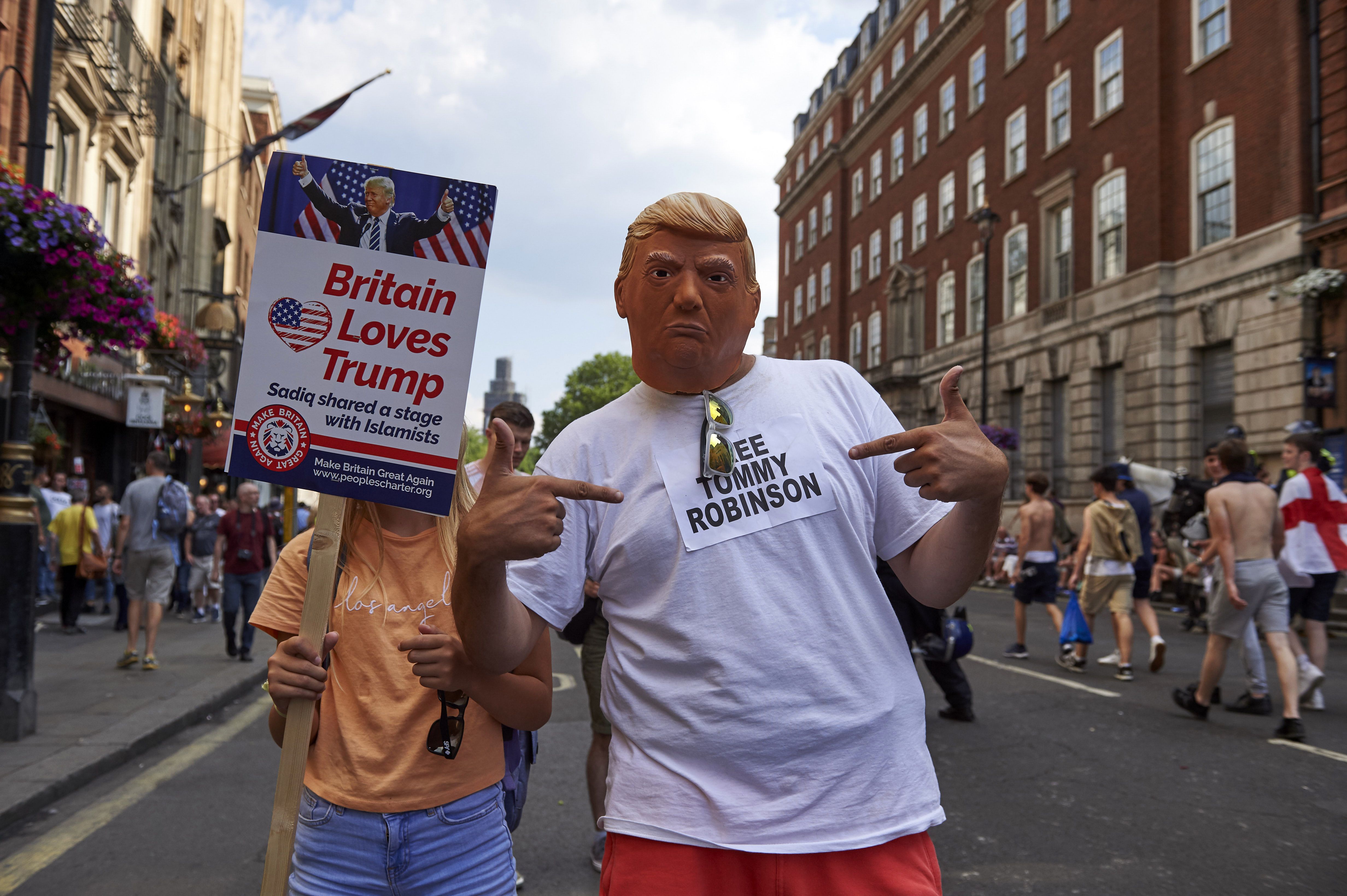 US President Donald Trump supporters pose for the camera as they mix with protesters at a rally by supporters of far-right spokesman Tommy Robinson in Trafalgar Square in central London on July 14, 2018, following the jailing of Tommy Robinson for contempt of court. (Photo by Niklas HALLE'N / AFP) (Photo credit should read NIKLAS HALLE'N/AFP/Getty Images)