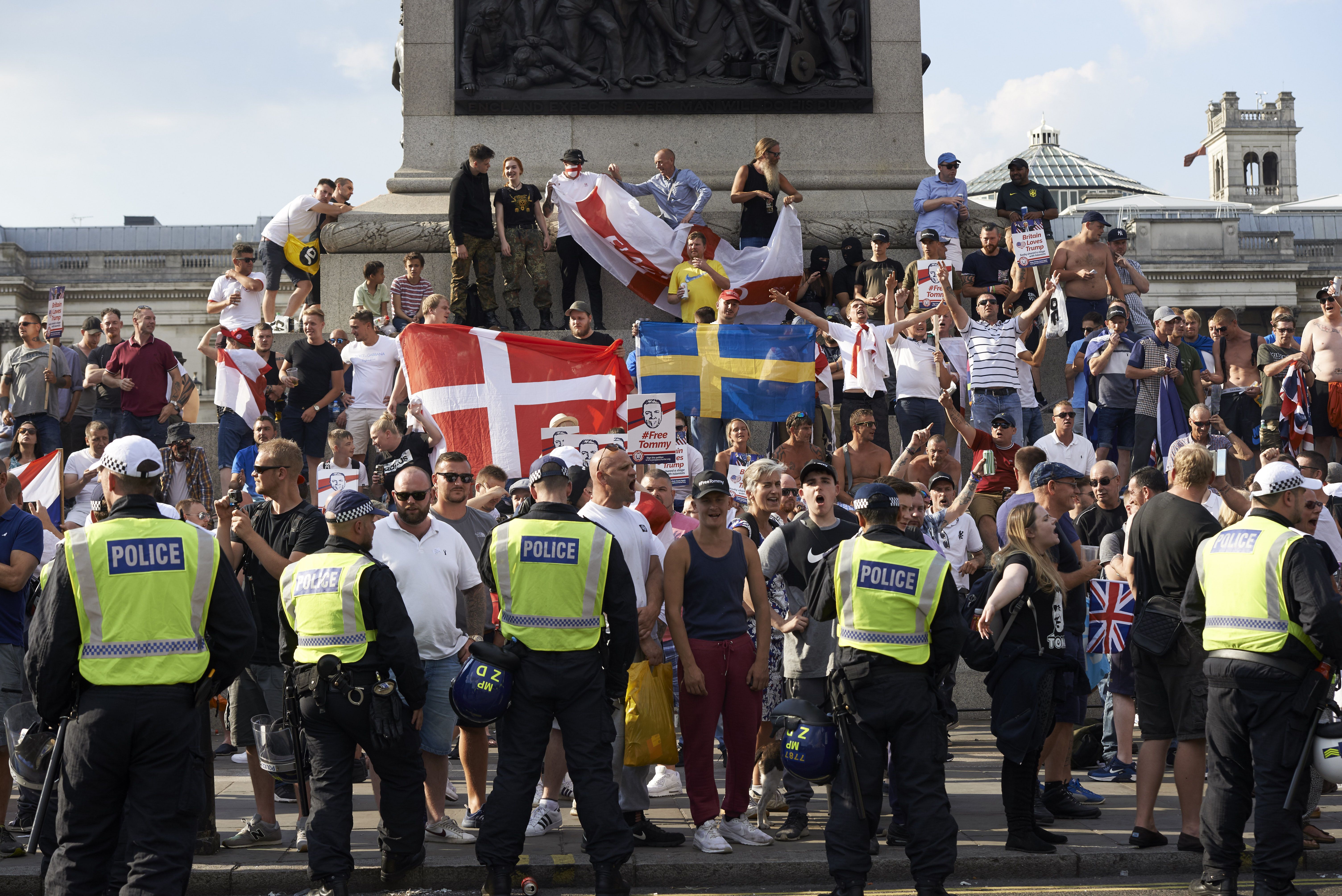 Protesters hold up flags and chant at a rally by supporters of far-right spokesman Tommy Robinson in Trafalgar Square in central London on July 14, 2018, following the jailing of Tommy Robinson for contempt of court. (Photo by Niklas HALLE'N / AFP) (Photo credit should read NIKLAS HALLE'N/AFP/Getty Images)