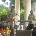 Man convinces African jazz band he can play the saxophone. He really, really can’t