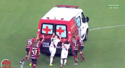 Ambulance breaks down on football pitch, players help to push it off