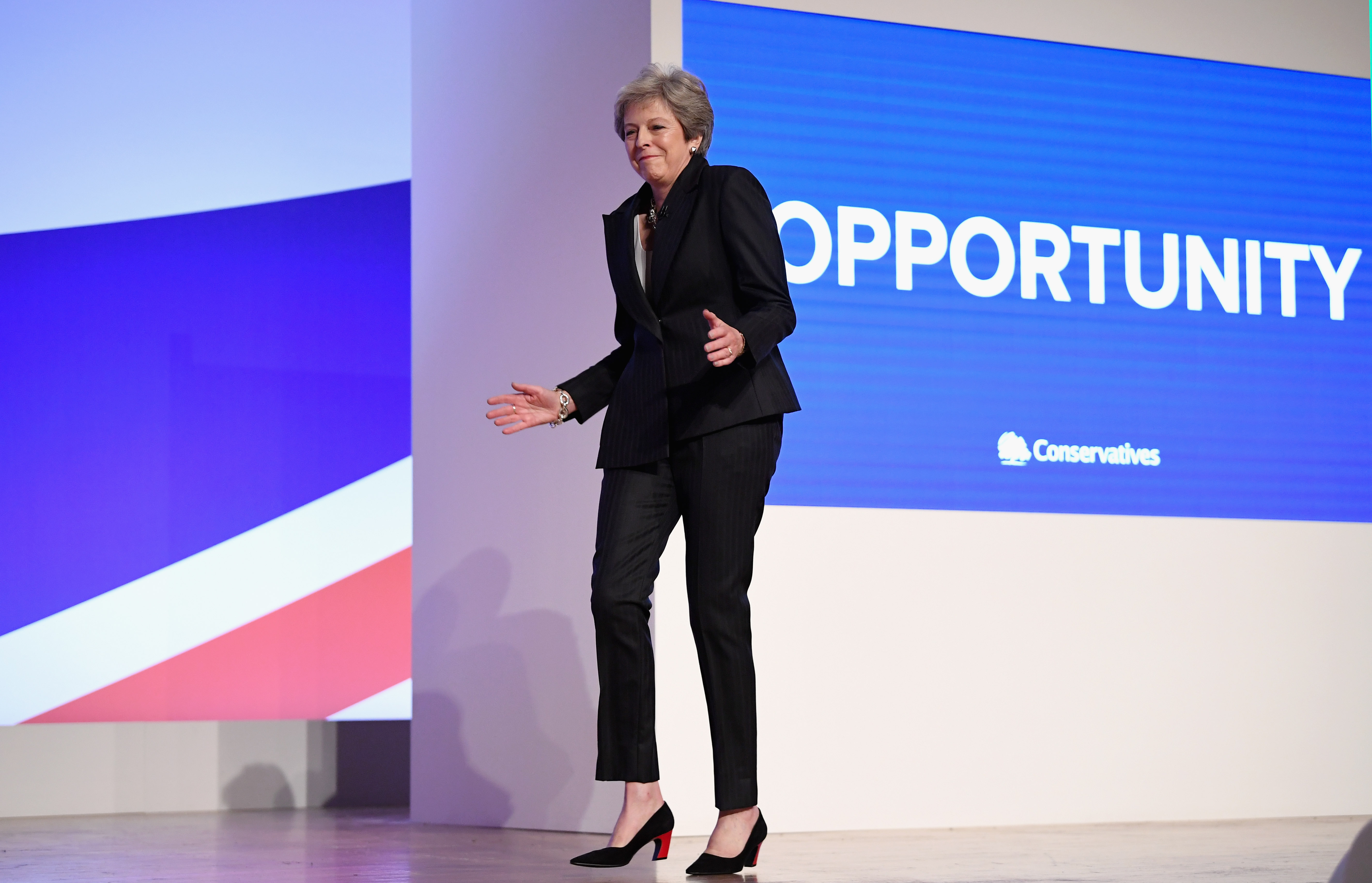 BIRMINGHAM, ENGLAND - OCTOBER 03:  British Prime Minister Theresa May dances as she walks out onto the stage to deliver her leader's speech during the final day of the Conservative Party Conference at The International Convention Centre on October 3, 2018 in Birmingham, England. Theresa May delivered her leader's speech to the 2018 Conservative Party Conference today. Appealing to the "decent, moderate and patriotic", she stated that the Conservative Party is for everyone who is willing to "work hard and do their best". This year's conference took place six months before the UK is due to leave the European Union, with divisions on how Brexit should be implemented apparent throughout.  (Photo by Jeff J Mitchell/Getty Images)