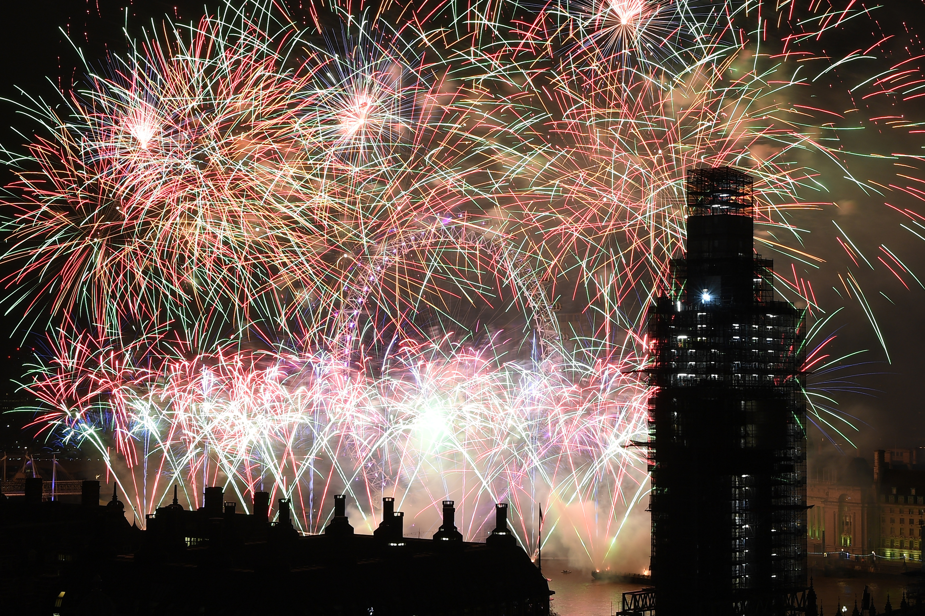 LONDON, ENGLAND - JANUARY 01: Fireworks explode over Westminster Abbey and Elizabeth Tower near Parliament as thousands of revelers gather along the banks of the River Thames to ring in the New Year on January 1, 2019 in London, England. Parliament confirmed that after being silenced for renovation work since 2017, Big Ben's famous bongs would ring out at midnight again to welcome in 2019. (Photo by Leon Neal/Getty Images)