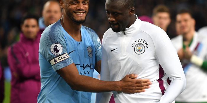 MANCHESTER, ENGLAND - MAY 09: Vincent Kompany of Manchester City embraces Yaya Toure of Manchester City as he is presented with a shirt in a frame during the Premier League match between Manchester City and Brighton and Hove Albion at Etihad Stadium on May 9, 2018 in Manchester, England. (Photo by Gareth Copley/Getty Images)