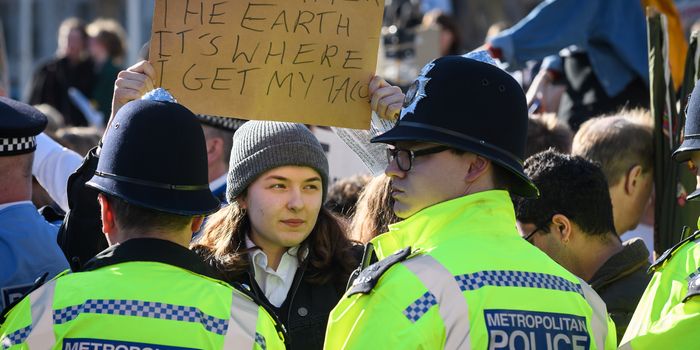 LONDON, ENGLAND - FEBRUARY 15: A student holds up her placard as members of the police attempt to clear the roads around Parliament Square during a climate protest on February 15, 2019 in London, United Kingdom. Thousands of UK pupils from schools, colleges and universities will walk out today for a nationwide climate change strike. Students in 60 cities from the West Country to Scotland are protesting, urging the government to declare a climate emergency and take action over the problem. They are keen that the national curriculum is reformed and the environmental crisis is communicated to the public. Similar strikes have taken place in Australia and in European countries such as Belgium and Sweden. (Photo by Leon Neal/Getty Images)