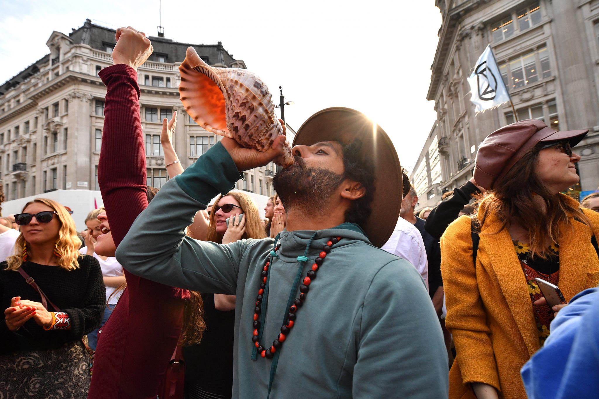 A protester at the Extinction Rebellion demonstration in Oxford Circus sounds a conch (Credit: Leon Neal)