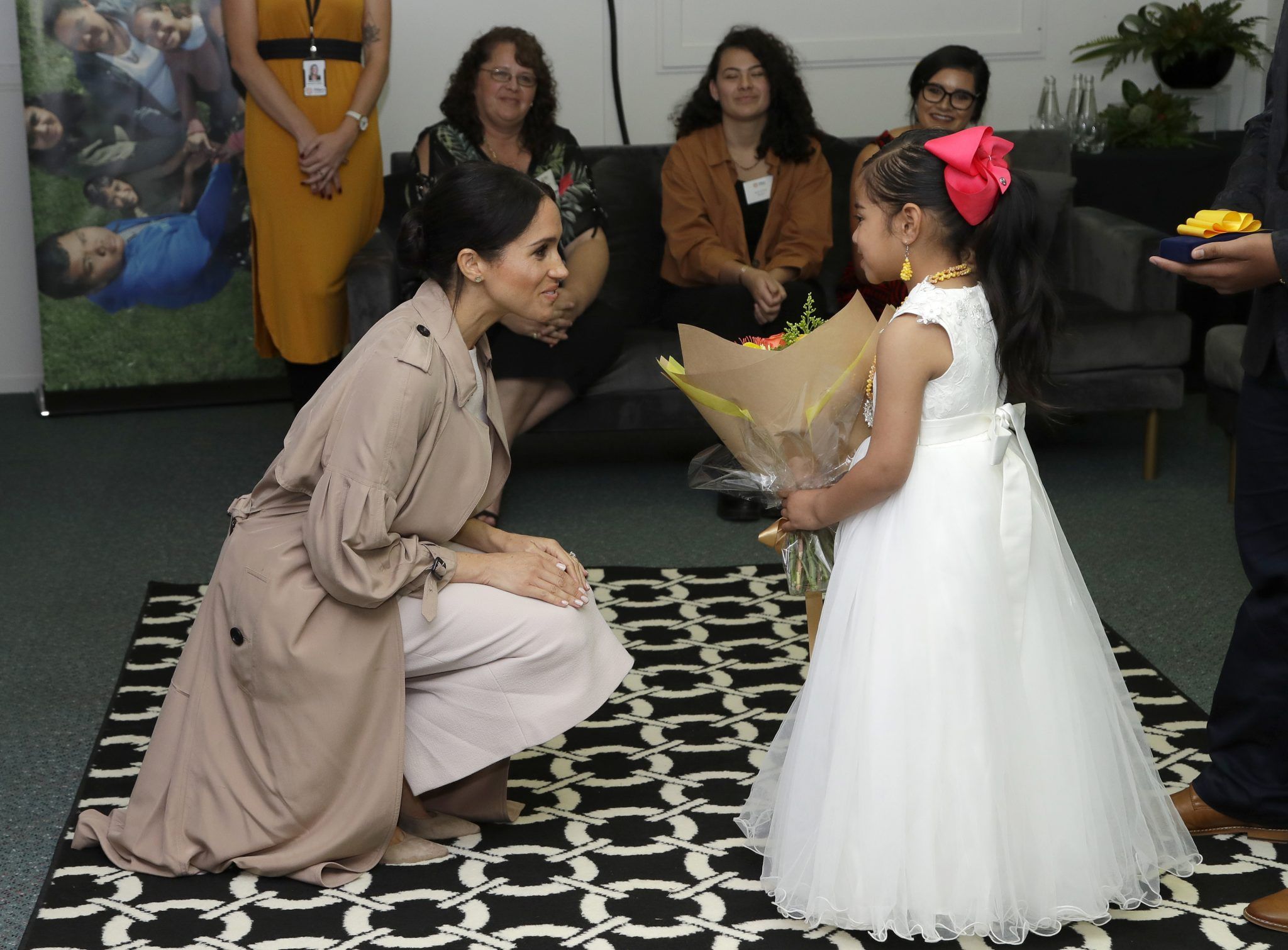 Meghan Markle with a child with flowers