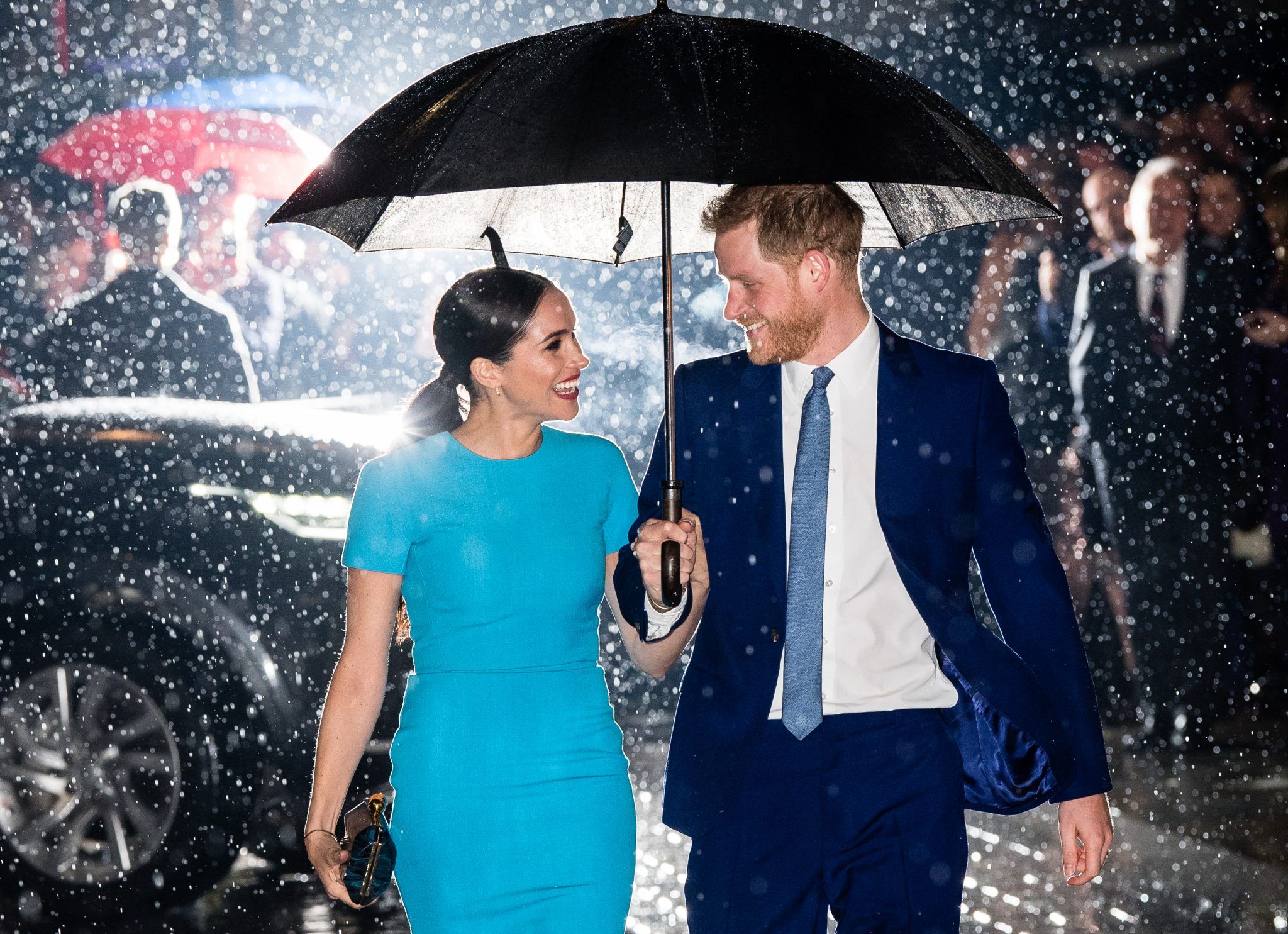 Harry and Meghan under an umbrella in the rain