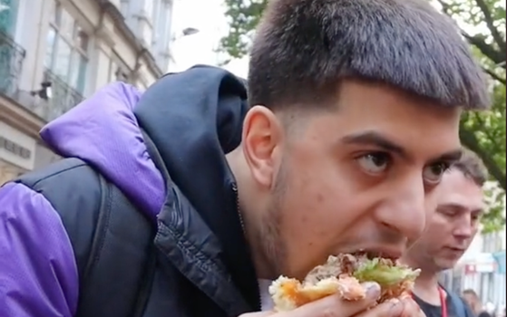 Prankster eats burger in front of vegan protestors