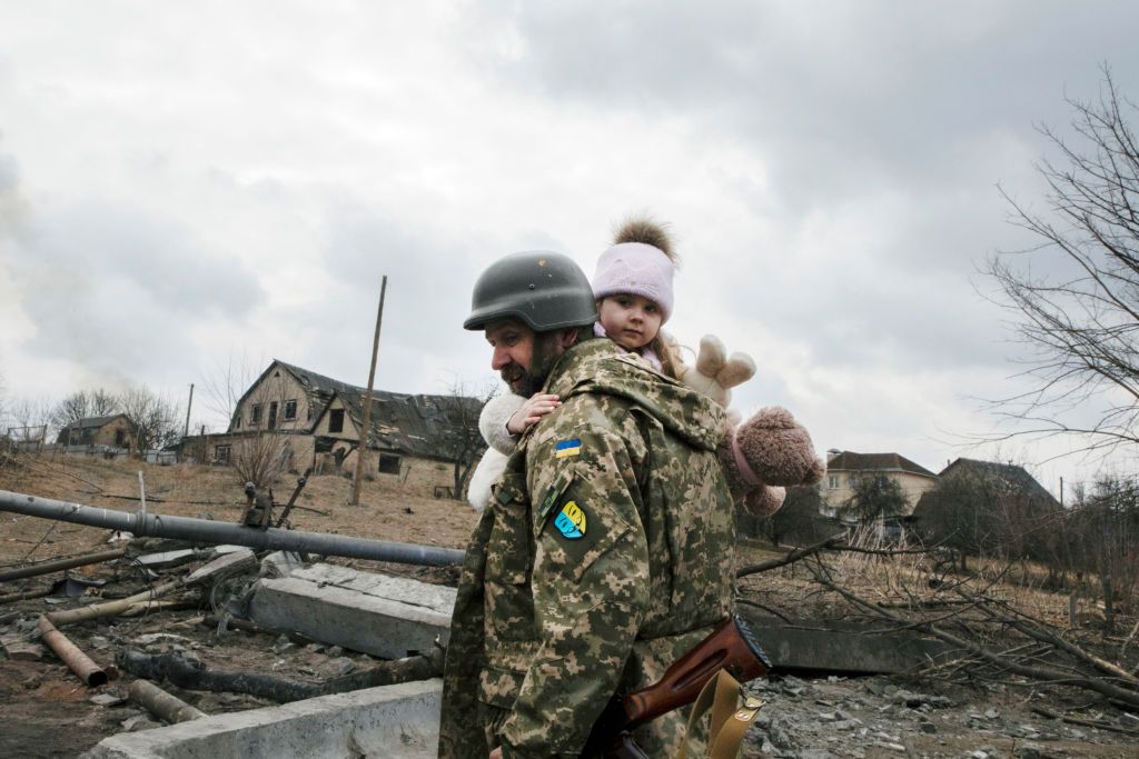 A Ukrainian soldier carries a child while evacuating from Irpin under the heavy shelling in Irpin, Ukraine on March 6 (Getty)