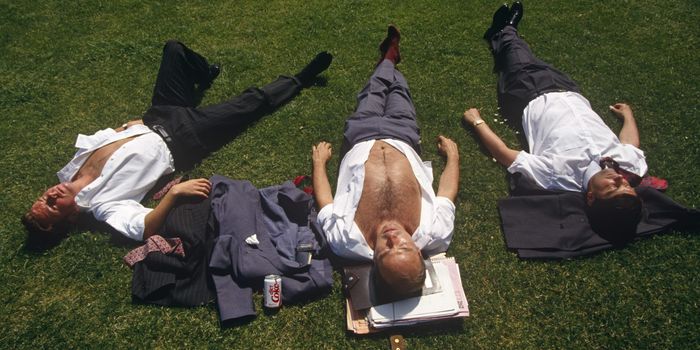 Looking down from above, we see young men who are open-chested and with their suit jackets either beneath their heads or on the grass, three office co-workers stretch out over the lush grass and sunbathe during a hot summer lunchtime in Trinity Square in the City of London, England. One has his paperwork under his head and a can of Coke to quench his thirst. Already tanned, the threesome bask under a hot mid-day sun. Risking sunburn after prolonged solar radiation exposure, they enjoy the inner-city heatwave. (Photo by In Pictures Ltd./Corbis via Getty Images)