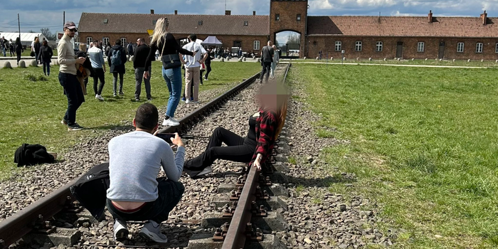 Woman poses on train tracks at Auschwitz